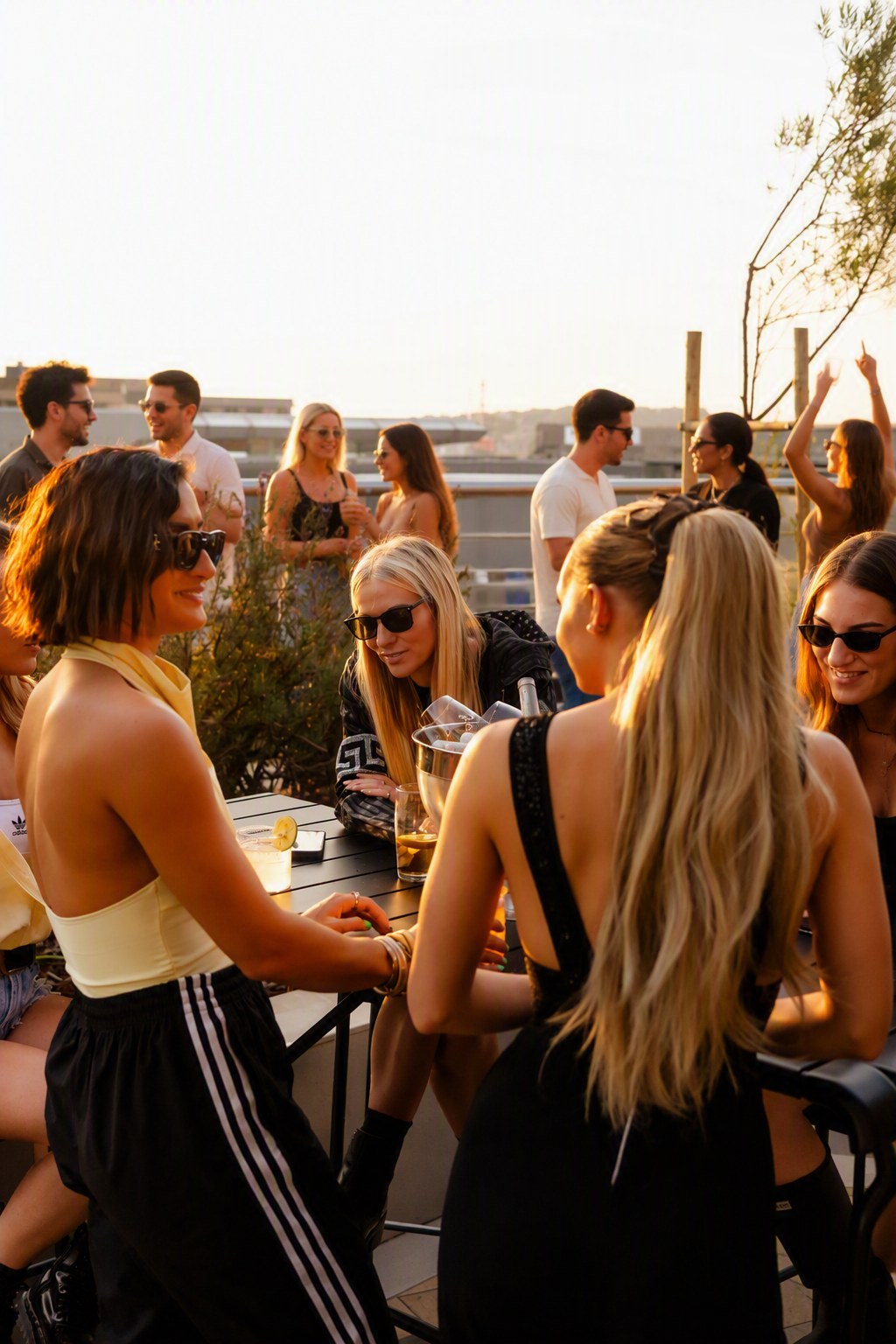 Golden hour on the Ocasa rooftop, guests at the tables as the sun drops
